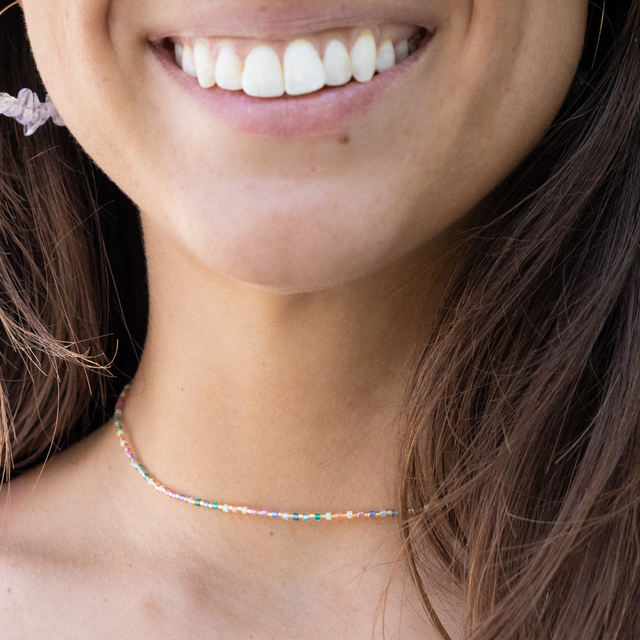 Close-up of a person wearing a colorful beaded waterproof choker necklace