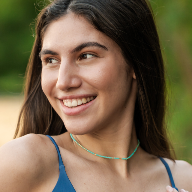 Teal & gold beaded waterproof surfer choker on a model