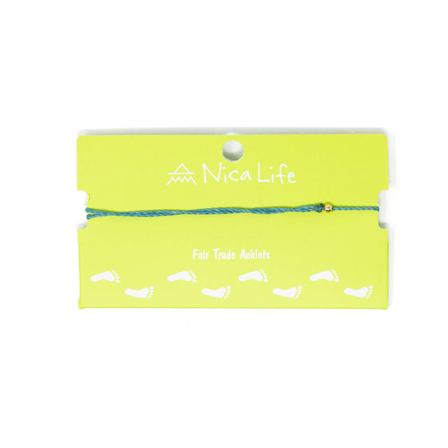 Teal string anklet with single gold filled bead shown on a green Nica Life branded card