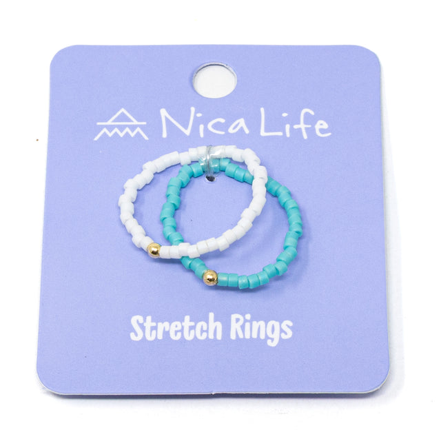 Set of turquoise and white beaded stretch rings on a purple Nica Life branded card.