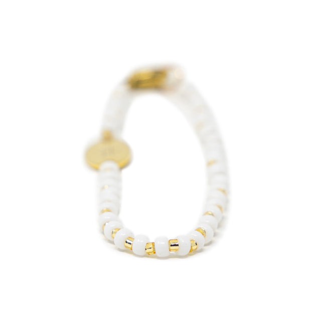 White & gold beaded bag charm shown on white