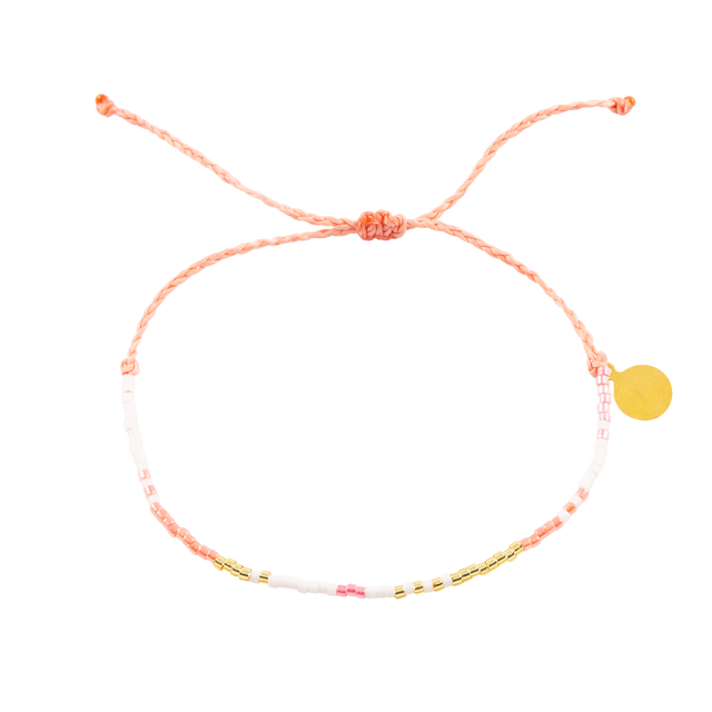 Coral pink and gold seed bead bracelets on white shown fro the top