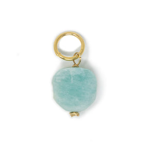 Turquoise color amazonite stone ciharm with gold ring on a white background