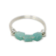 Three raw amazonite stones on silver ring on white