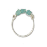 Three raw amazonite stones on a silver ring shown on white