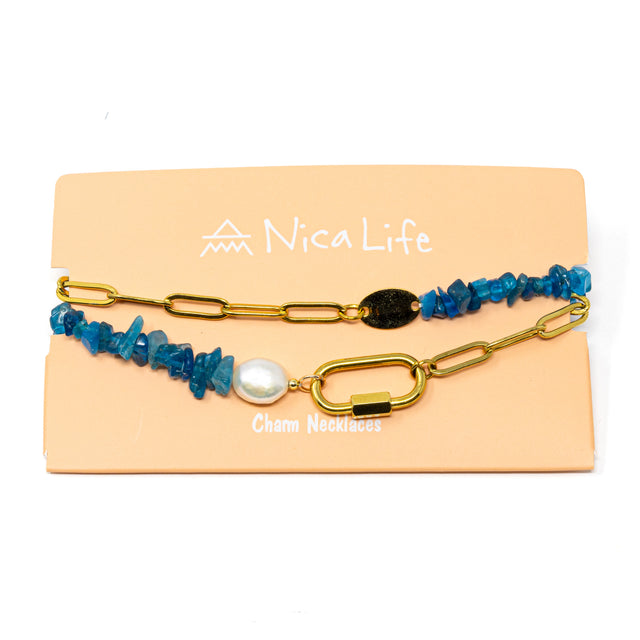 Charm necklace made with apatite beads, a pearl, and gold chain with a carabiner clasp on a 'Nica Life' branded card with a white background