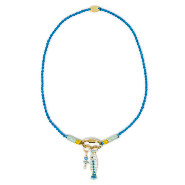 Blue necklace with a gold carabiner clasp holding a fish & stone charm on a white background
