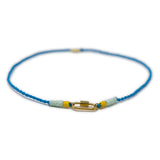 Hand made blue cord bracelet with a gold carabiner clasp for charms on a white background