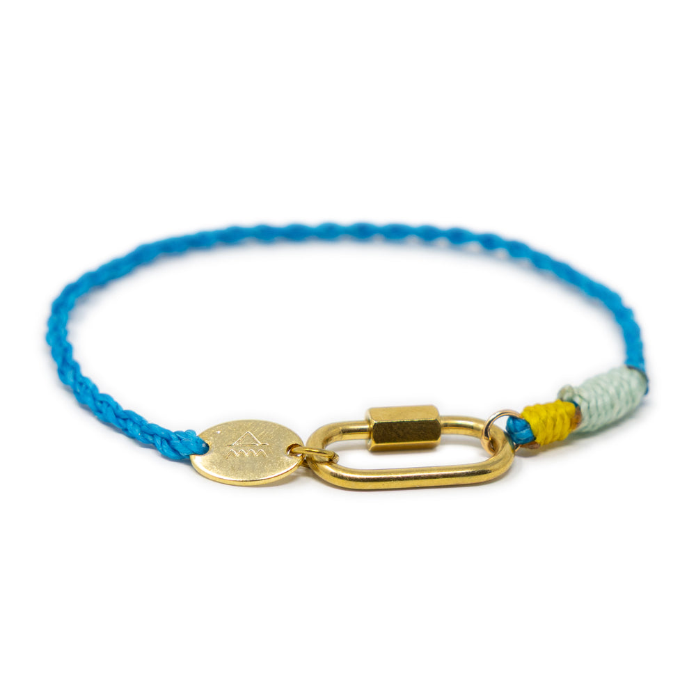 Charm gracelet with blue cord, gold carabiner clasp, and colorful accents on a white background