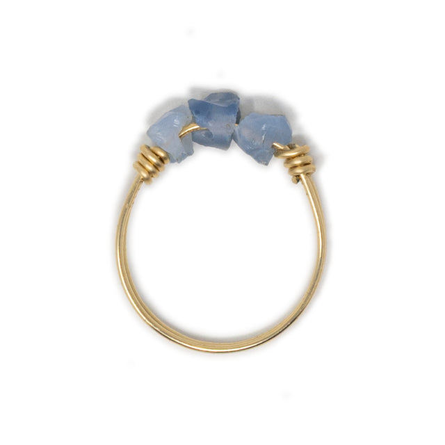Three blue opal stones on a gold ring shown on white top view