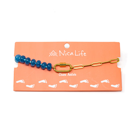 Blue stone bead and gold chain charm bar anklet with a gold carabiner for charms on a coral colored Nica Life branded card