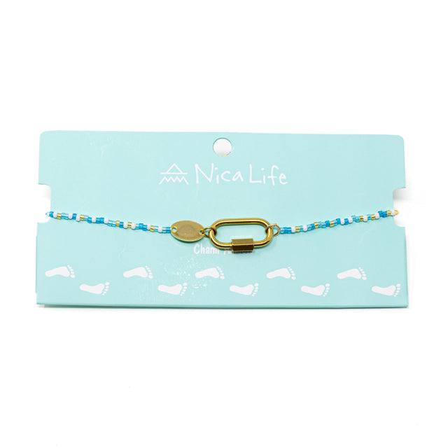 Blues & gold beaded charm bar anklet with carabiner clasp for charms show on teal Nica Life branded card.