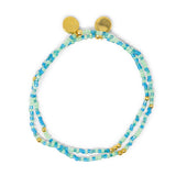 Two blues greens and teal beaded with gold filled bracelets stacked together on white. 