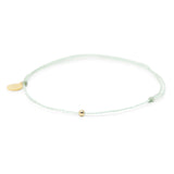 Cucumber mint color thread anklet with a gold filled bead on white front view