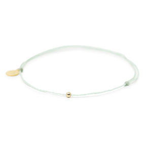 Cucumber mint color thread anklet with a gold filled bead on white front view
