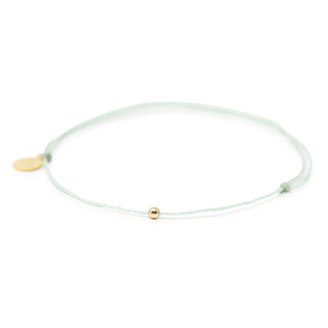 Cucumber mint color thread anklet with a gold filled bead on white front view
