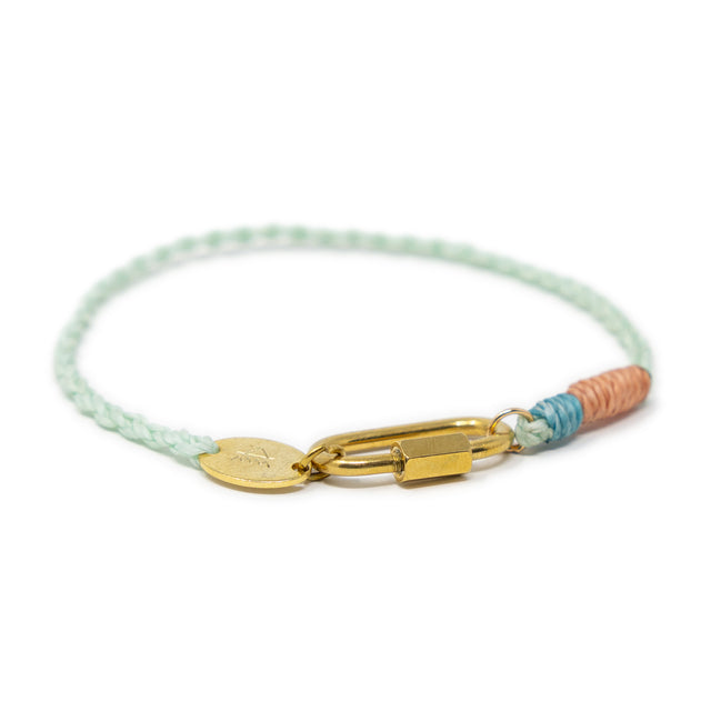 Charm bracelet with gold carabiner clasp and colorful cord accents on a white background