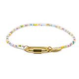 Bright multicolored beaded charm bar bracelet with a gold carabiner clasp for charms on a white background