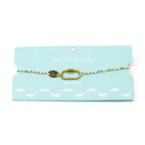 Bright color beaded charm bar anklet with carabiner claps for charms on teal Nica Life branded card. 