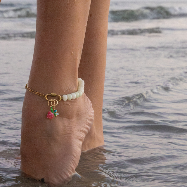 Mint stone pony bead charm bar anklet on modle on the beach with a strawberry & stone  charm