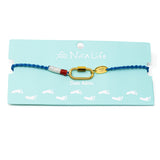 Hand braided cord anklet in nautical colors with a gold carabiner dlasp for charms shown a Nica Life branded card.
