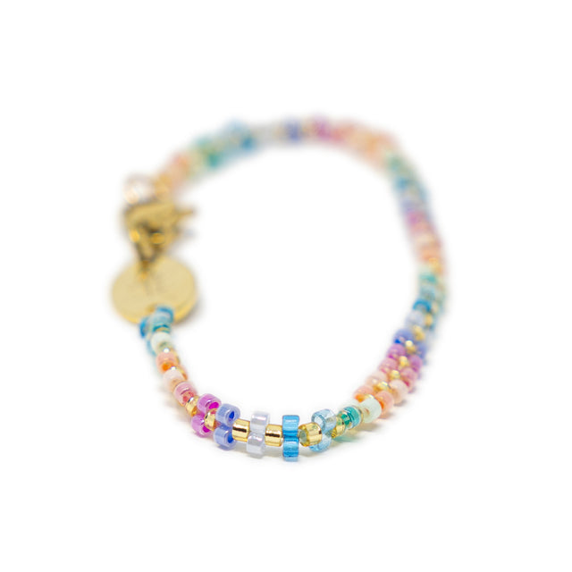 Multicolored beaded bag charm with gold accents on a white background
