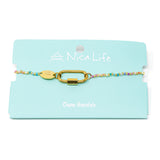 Colorful beaded charm bar bracelet with a carabiner clsap for charms on a teal Nica Life branded card