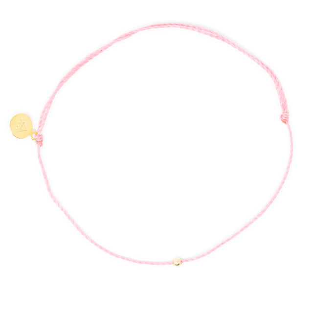 Pink thread anklet on white with single gold filled bead on white top view