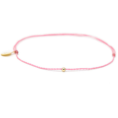Pink thread anklet on white with single gold filled bead on white