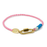 Bracelet with pink cord, gold carabiner clasp for charms on a white background