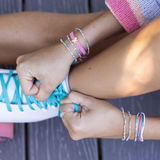Pink & Teal Bracelets model tying skates