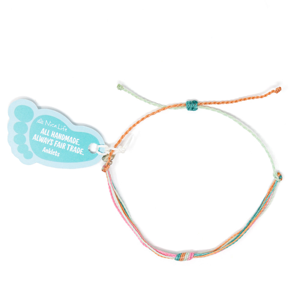 Colorful string knot ankelt shown with Nica Life branded foot shaped tag shown on white