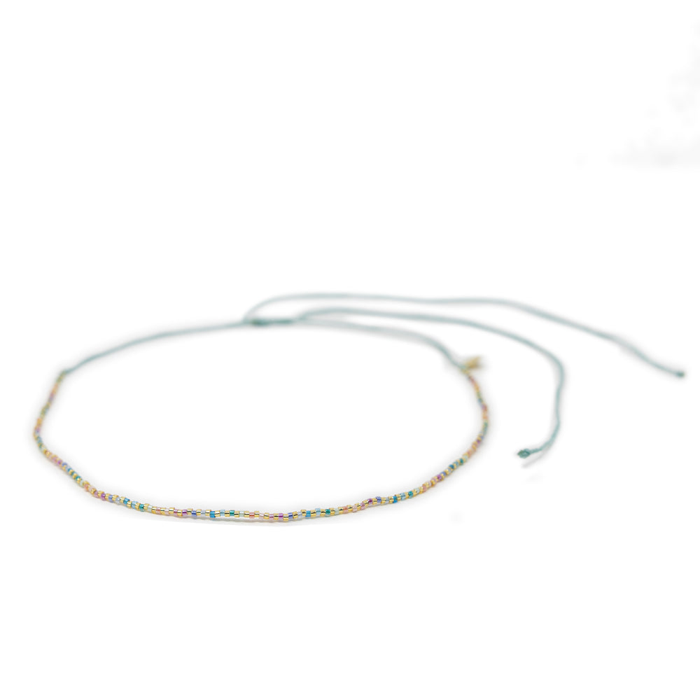 Beaded waterproof choker in pastel rainbow colors on a white background