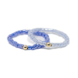 Two purple beaded rings with gold beads on a white background