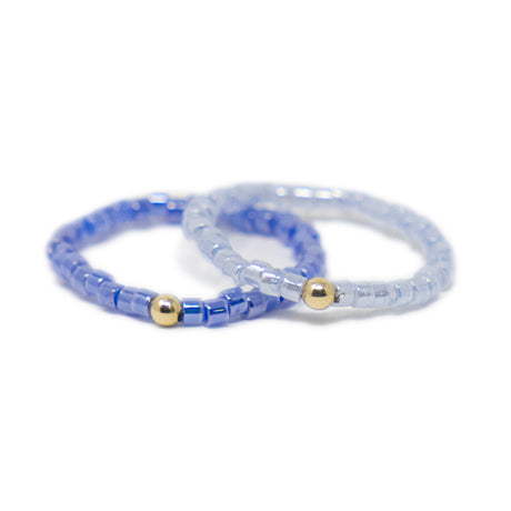 Two purple beaded rings with gold beads on a white background