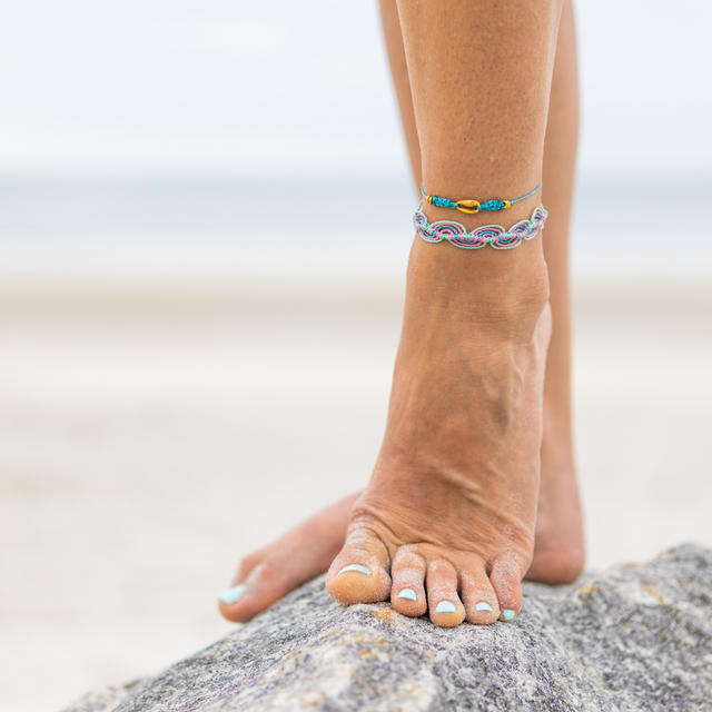 Teal Cowrie Puka Shell String Anklet Stack on Rock