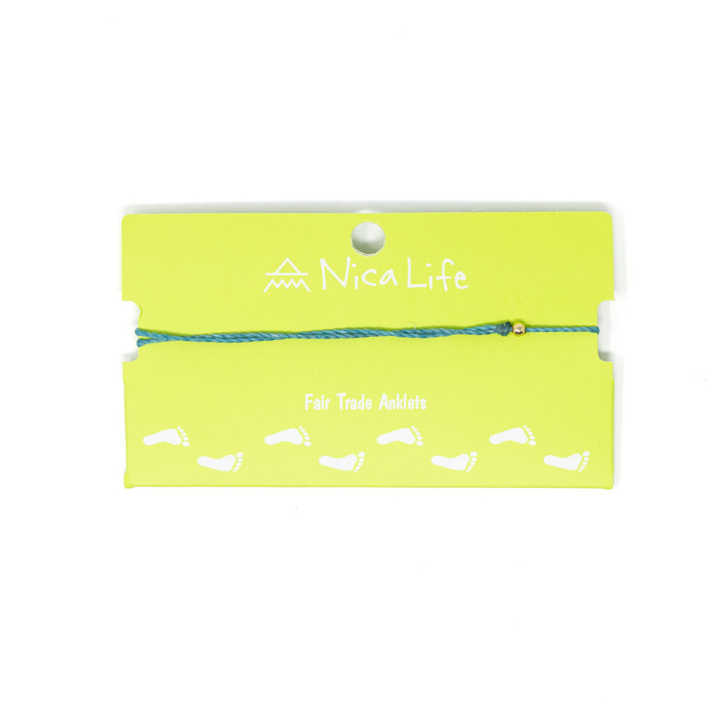 Teal string anklet with single gold filled bead shown on a green Nica Life branded card
