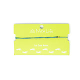 Teal string anklet with single gold filled bead shown on a green Nica Life branded card