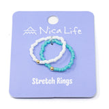 Set of turquoise and white beaded stretch rings on a purple Nica Life branded card.