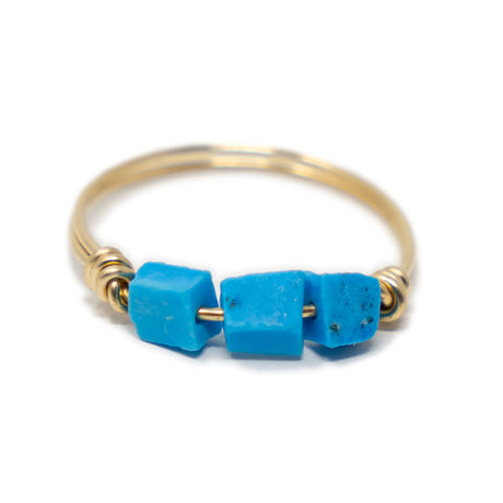 Three raw turquoise stones on a gold ring shown on white front view