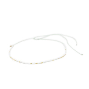 White & gold waterproof choker necklace for surfer girls on white background, adjustable with waterproof cord