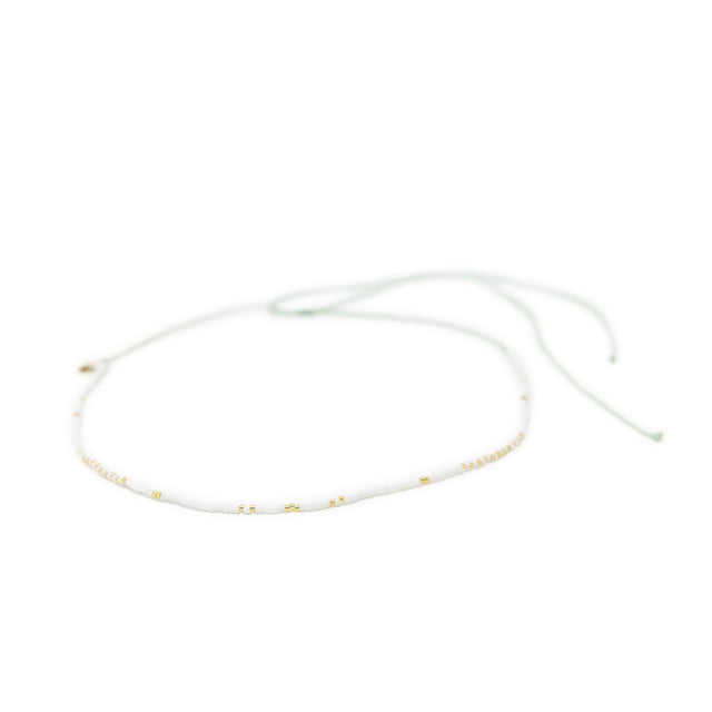 White & gold waterproof choker necklace for surfer girls on white background, adjustable with waterproof cord