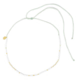 White waterproof surfer girl choker necklace with gold accents on a white background