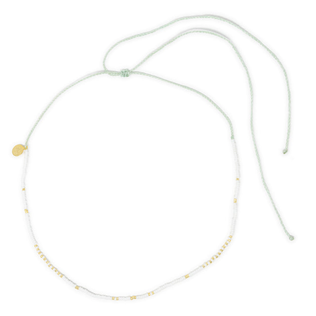 White waterproof surfer girl choker necklace with gold accents on a white background
