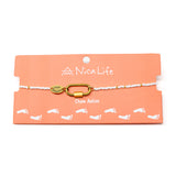 White & gold charm bar anklet with carabiner for charms shown on a coral Nica Life branded card