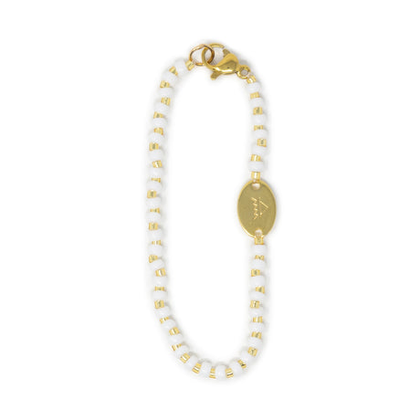 White and gold beaded bag charm with a gold clasp on a white background
